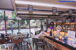 A woman in a bikini sitting at a bar.