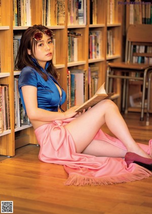 A woman in a pink dress is posing for a magazine cover.
