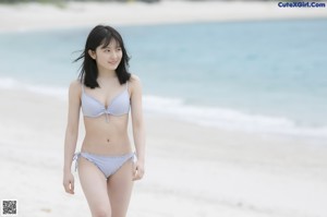 A woman in a white shirt standing next to a boat.