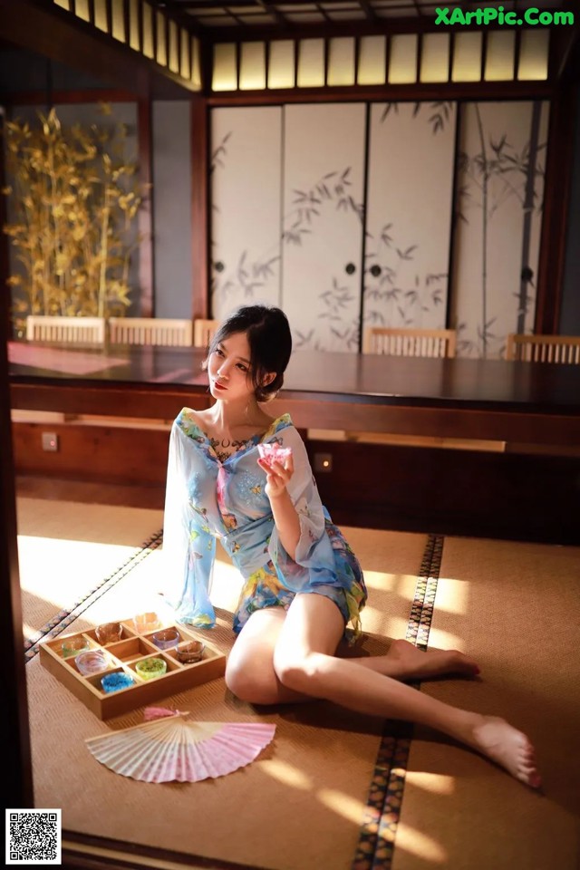 A woman sitting on the floor in a room.