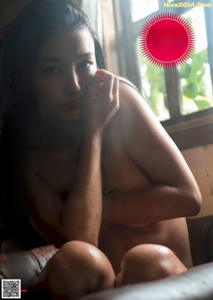 A woman in lingerie sitting on a wooden bench.