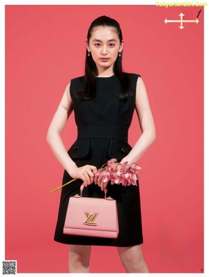 A woman in a black suit and a black bag.