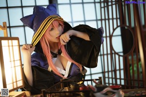 A woman with pink hair wearing a cat ears headband.