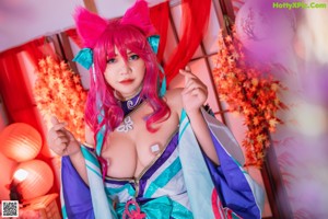 A woman with pink hair sitting on a couch.