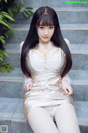 A woman in lingerie sitting on a white couch.