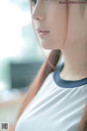 A woman in a blue and white shirt is posing for a picture.