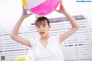 A woman sitting on top of a yellow and white ball.