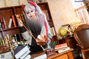 A woman dressed as a nurse sitting on top of a desk.