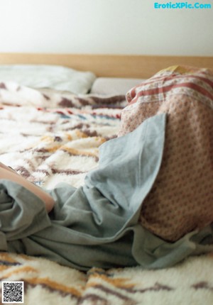 A woman in a green sweater is looking out a window.