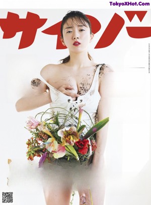 A woman laying on the floor surrounded by flowers.