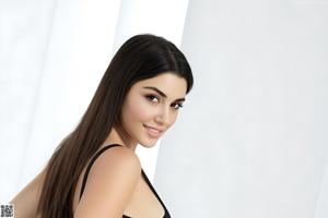 A woman in a black bra and panties posing for a picture.